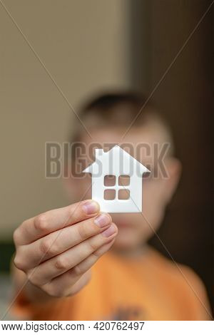 Orphanage, Children In The Orphanage. The Child Is Holding A Small House-shaped Figurine, Close-up. 