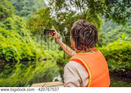 Man Tourist In Trang An Scenic Landscape Complex In Ninh Binh Province, Vietnam A Unesco World Herit