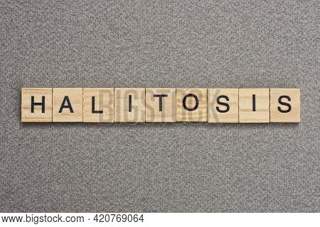 Text The Word Halitosis From Wooden Small Letters With Black Font On An Gray Table