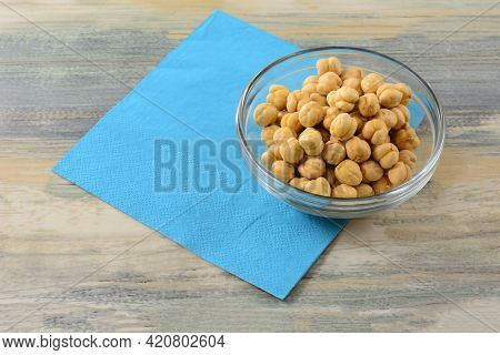 Turkish Salted Roasted Chickpeas In Glass Snack Bowl With Blue Napkin On Table