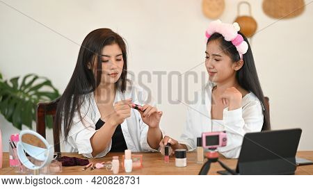 Women Are Showing How To Make Up Via Online Video At The Wooden Dressing Table.