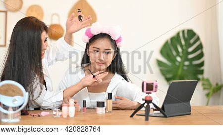 Women Are Showing How To Make Up Via Online Video At The Wooden Dressing Table.