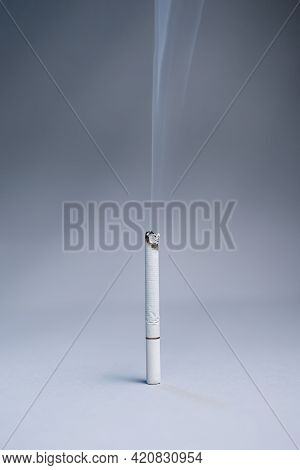 World Tobacco Day. One Smoking Cigarette Stands On A Gray Background. Vertical Orientation. Copy Spa