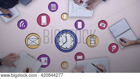 Composition of online digital icons over people writing in meeting on pink background. global online business and digital interface concept digitally generated image.