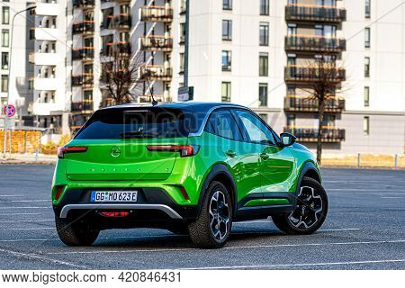 Riga, Latvia - 26 March, 2021: Green Electric Vehicle Opel Mokka-e In The Parking Lot On The Backgro