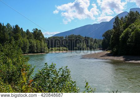 Skeena River: A Wide River Beneath A Blue Sky. Travelling In The Canadian Rocky Mountains.