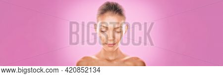 Natural Asian beauty woman model zen with closed eyes meditating calm on pink background. Young girl with slight smile pensive relaxing. Skincare clear dewy skin concept panoramic banner.