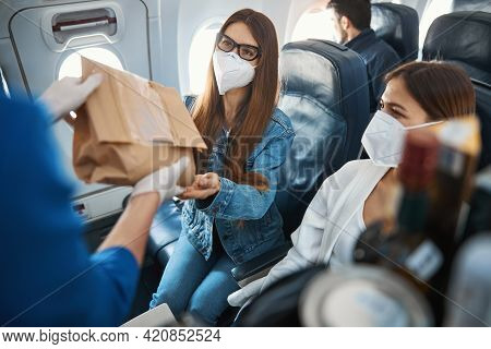 Female On Window Seat Getting Package From Cabin Crew