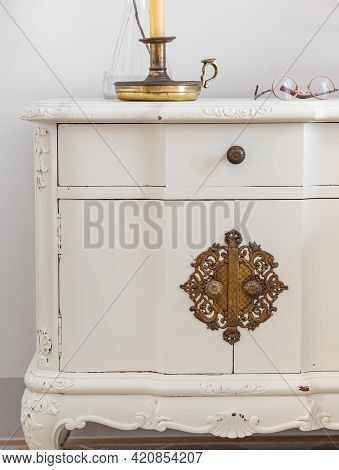Close-up Of Vintage Wooden Bedside Table With Metal Fitment. Candle And Glasses For Reading For Cosy