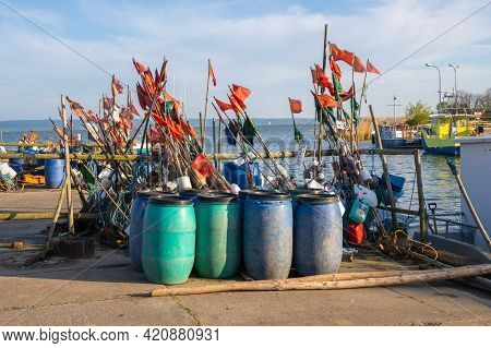 Krynica Morska, Poland - May 15, 2021: Fishing Barrels And Flags In Port Of Krynica Morska Located O