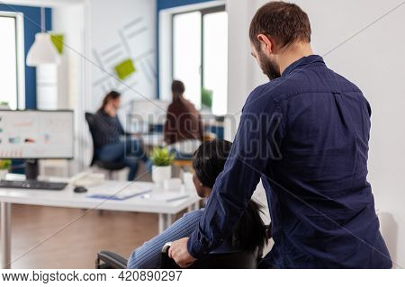 Businessman Helping His Disabled Black Colleague Entering In Company Office Pushing Wheelchair Near 