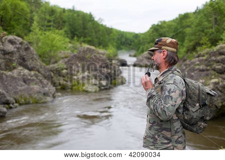Batohem, stojící na břehu horské řeky. Rusko. Primorskiy kray.