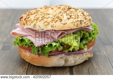 Everything Bagel Bun Envelops This Non Traditional Ham Sandwich Loaded With Lettuce, Meat Slices, An