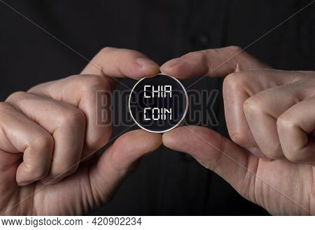 Chia Coin Concept. New Chiacoin In Male Hand Over Black Background.