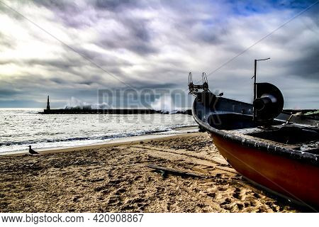 Fishing Boats Stranded On Aguda Beach And Giant Waves Breaking On The Breakwater And The Lighthouse 