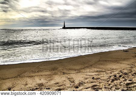 Breakwater With Lighthouse On Aguda Beach In The South Of Porto In A Cloudy Day