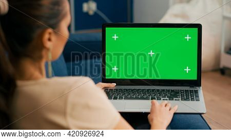 Close Up Of Freelencer Using Laptop Computer With Mock Up Green Screen Chroma Key Display While Sitt