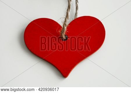 Wooden Red Heart On A String, On A White Background.