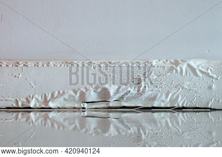 White Skirting Board Damaged By Destructive Elements From Moisture Or Water.
