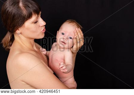 Mom Caresses Child With Hand And Measures Temperature With Thermometer To Baby. Mother Holding Her C