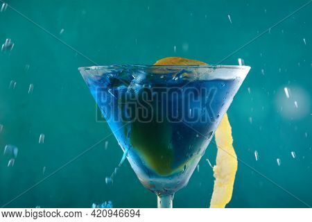 Blue Lagoon Cocktail With Blue Curacao Liqueur, Vodka, Lemon Juice And Soda, Decorated With Lemon Sl