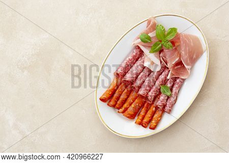 Meat Assortment, Salami Slices In Plate Decorated With Basil, Copy Space For Text.