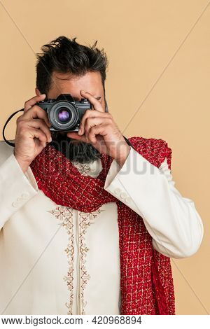 Indian man in a kurta with a digital camera