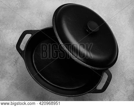 Cast Iron Pot With Lid. A Casserole Pot On A Gray Concrete Background. Empty Clean Castiron Cooking 