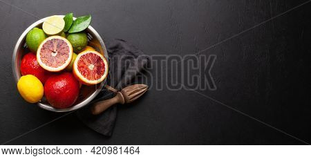 Various fresh citrus fruits in colander. Bood orange, lime, lemon. Top view flat lay with copy space