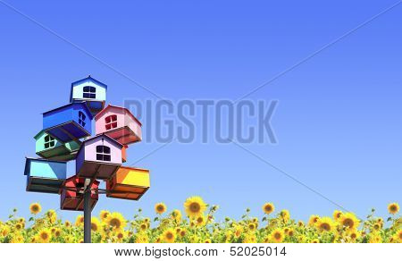 Colorful nesting boxes and sunflowers on blue sky