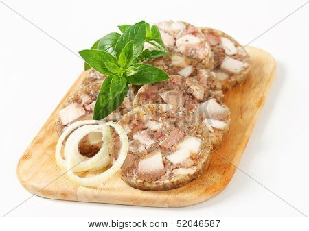 Sliced head cheese on a cutting board