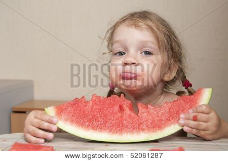 Two-year-old girl eating watermelon with cheerful faces