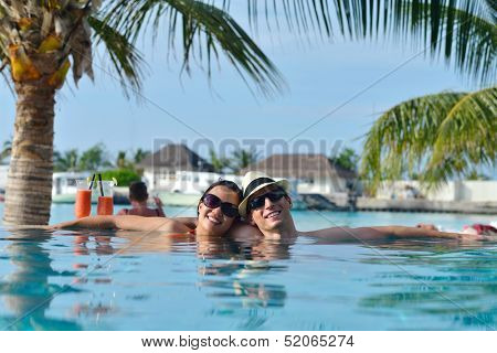 happy young couple relax and take fresh drink at summer vacation on swimmin pool