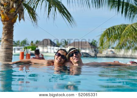 happy young couple relax and take fresh drink at summer vacation on swimmin pool
