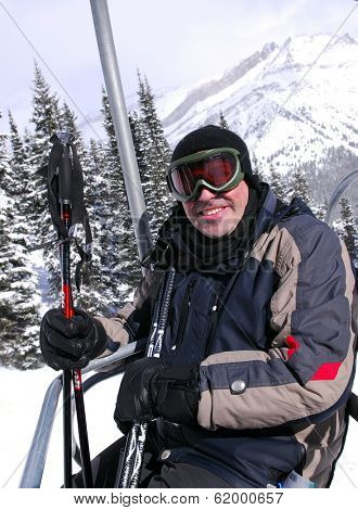 Happy man on a chairlift at downhill ski resort
