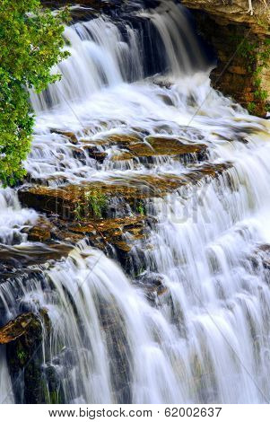 Beautiful cascading waterfall flowring over natural rock formation