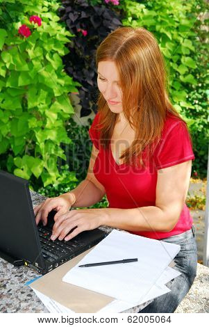 Woman working on her computer at home, small business owner