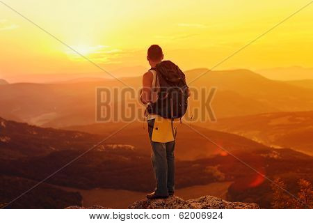 Guy In The Mountains At Sunset. The Concept Of Freedom