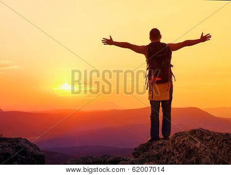 Guy In The Mountains At Sunset. The Concept Of Freedom