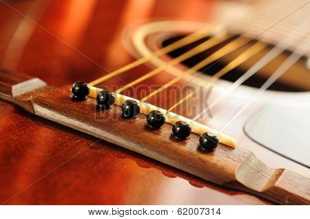Acoustic guitar bridge and strings close up