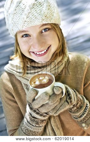 Teenage girl in winter hat with cup of hot chocolate
