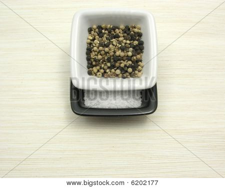 ชามเครื่องลายคราม Peppercorns และเกลือบน Underlay สีเบจ