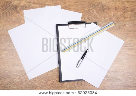 Clipboard, Pen, Straightedge And Paper On The Table
