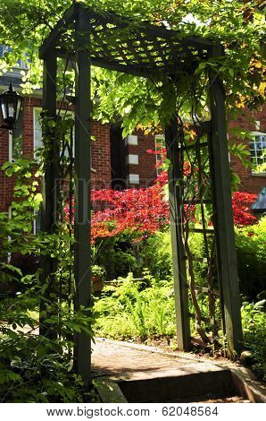 Landscaped front yard of a house with flowering garden and arbor