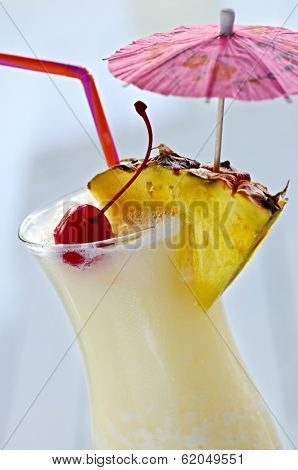 Pina colada drink in hurricane cocktail glass isolated on white background