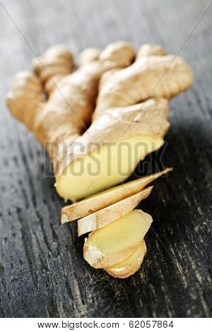 Close up of sliced fresh ginger root spice on wooden table