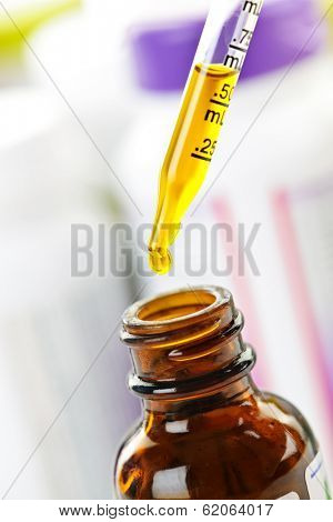 Closeup of liquid medicine in glass dropper and bottle