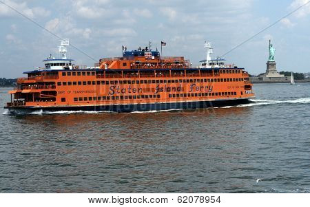 NEW YORK - JULY 11: The Staten Island ferry passes the Statue of Liberty  in New York City on Sunday, July 11, 2010