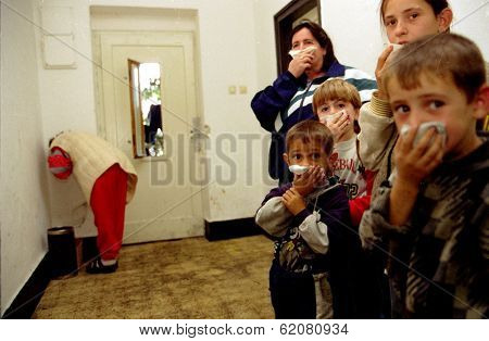 GYOR, HUNGARY - OCTOBER 14:  Kosovar Albanians at a Hungarian refugee center, some as young as eight, cover their noses while a Kosovar Albanian woman at rear convulses with stomach pains on October 14, 1998 in Gyor, Hungary