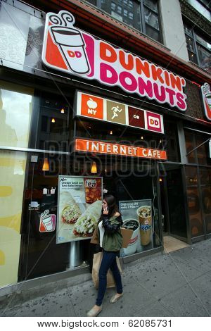 NEW YORK CITY - APRIL 19: Pedestrians walk past a Dunkin' Donuts franchise in New York City, on Friday, April 19, 2013.